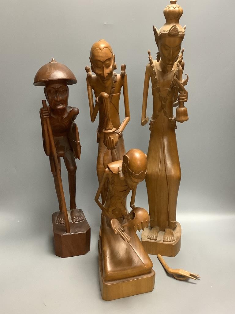 A group of three Balaris carved wood figures of mendicants and another similar figure, largest 52.5cm